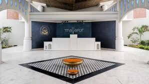 A reception area with a dark blue wall, a logo, and the word 'maayapur' in gold letters. - Hotel Sonar Bangla Mayapur (Krishnanagar)