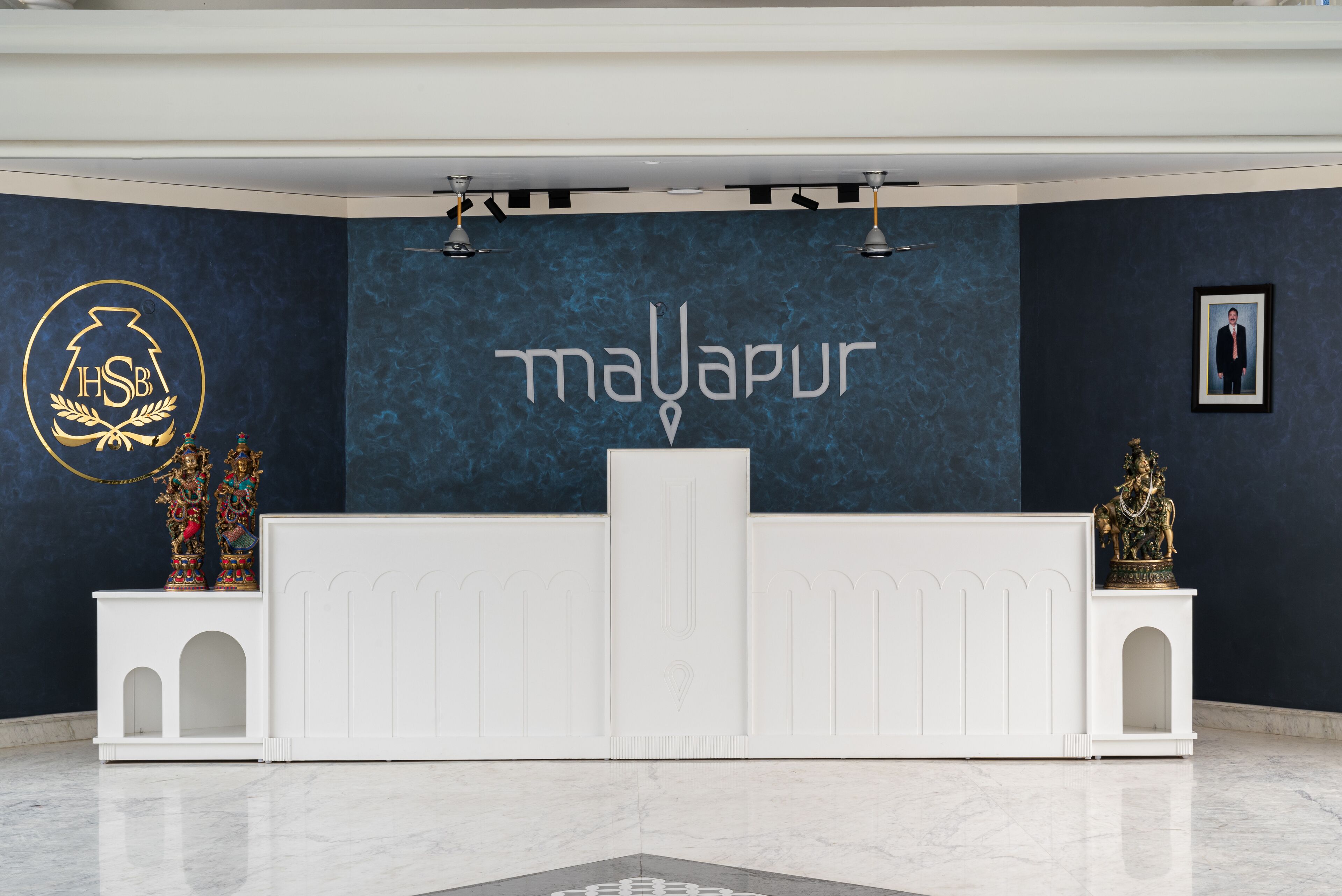 Una reception con una parete blu scuro e un logo al centro.