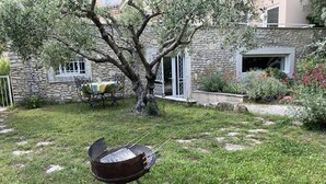 A backyard with a grill, a stone building, and a tree. - Calm and relaxation with a view of the Château and listed village, L'OLIVIER (Grignan)