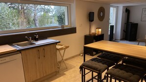 A modern kitchen with a wooden countertop, a built-in dishwasher, and a window overlooking greenery. - Calm and relaxation with a view of the Château and listed village, L'OLIVIER (Grignan)