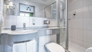 A modern bathroom with a granite countertop, a toilet, a glass shower enclosure, and a mirror. - flexy.motel Schönenwerd (Schonenwerd)