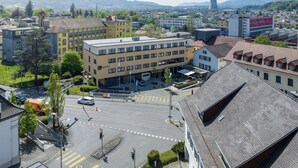 A hotel with a modern design, featuring a central courtyard and multiple floors. - flexy.motel Schönenwerd (Schonenwerd)