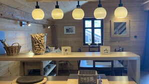 Un interior de madera con una encimera de cocina, armarios de madera y lámparas colgantes.