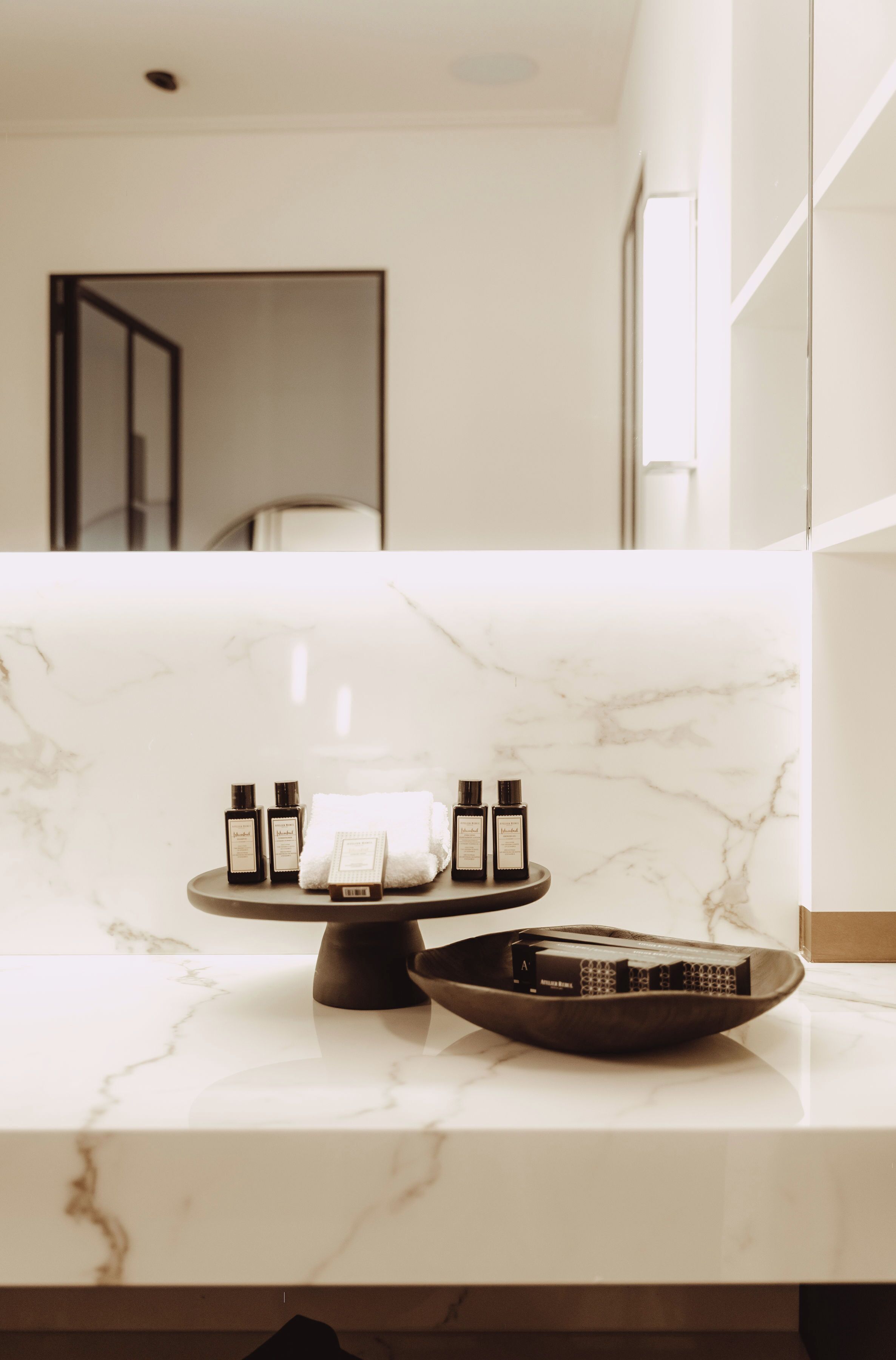A bathroom with a marble countertop, a towel rack, and toiletries.