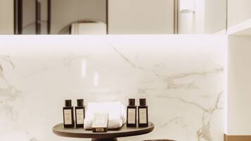 A bathroom with a marble countertop, a towel rack, and toiletries.