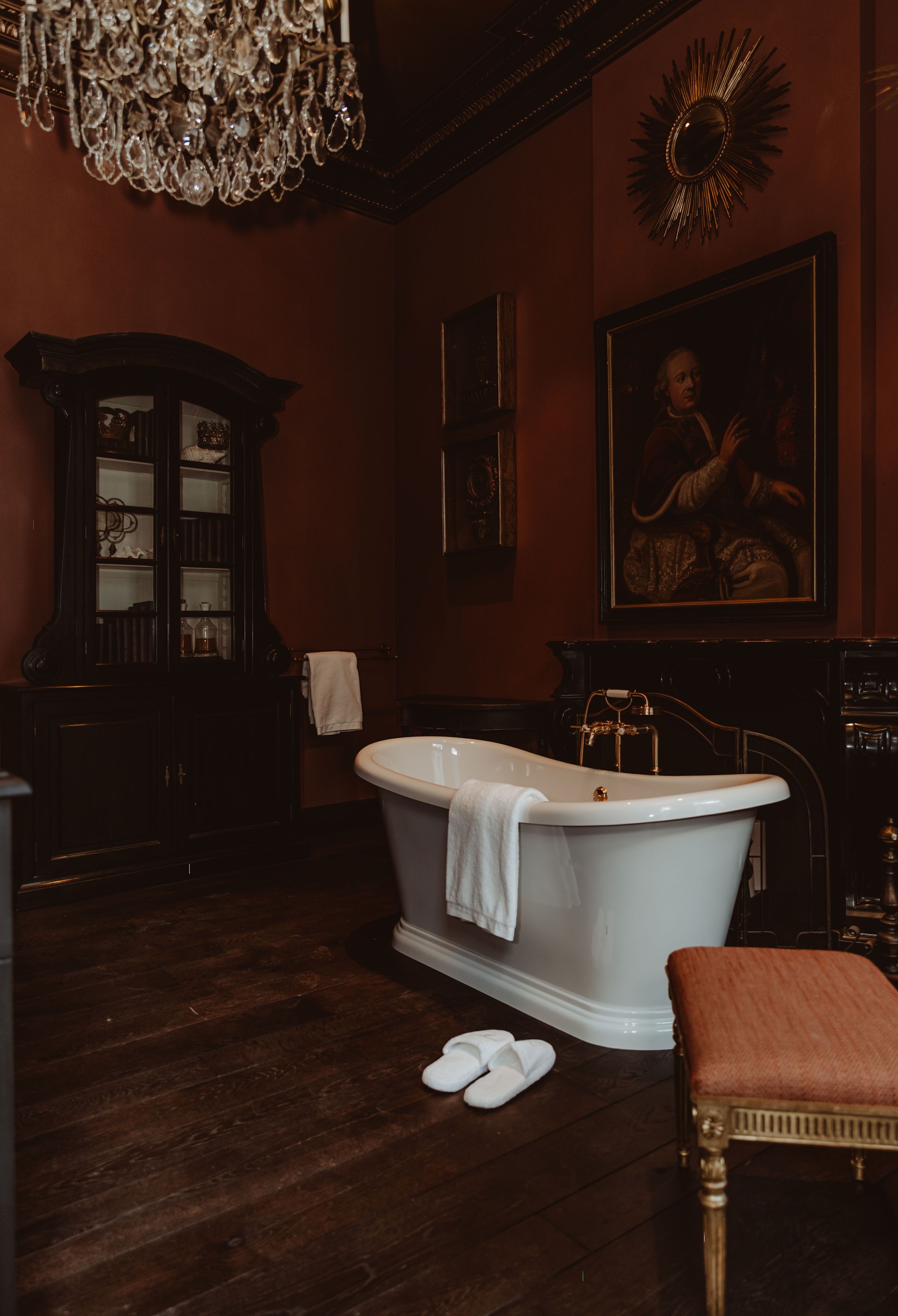 Une salle de bain classique avec une baignoire sur pieds, un meuble en bois et un grand miroir.