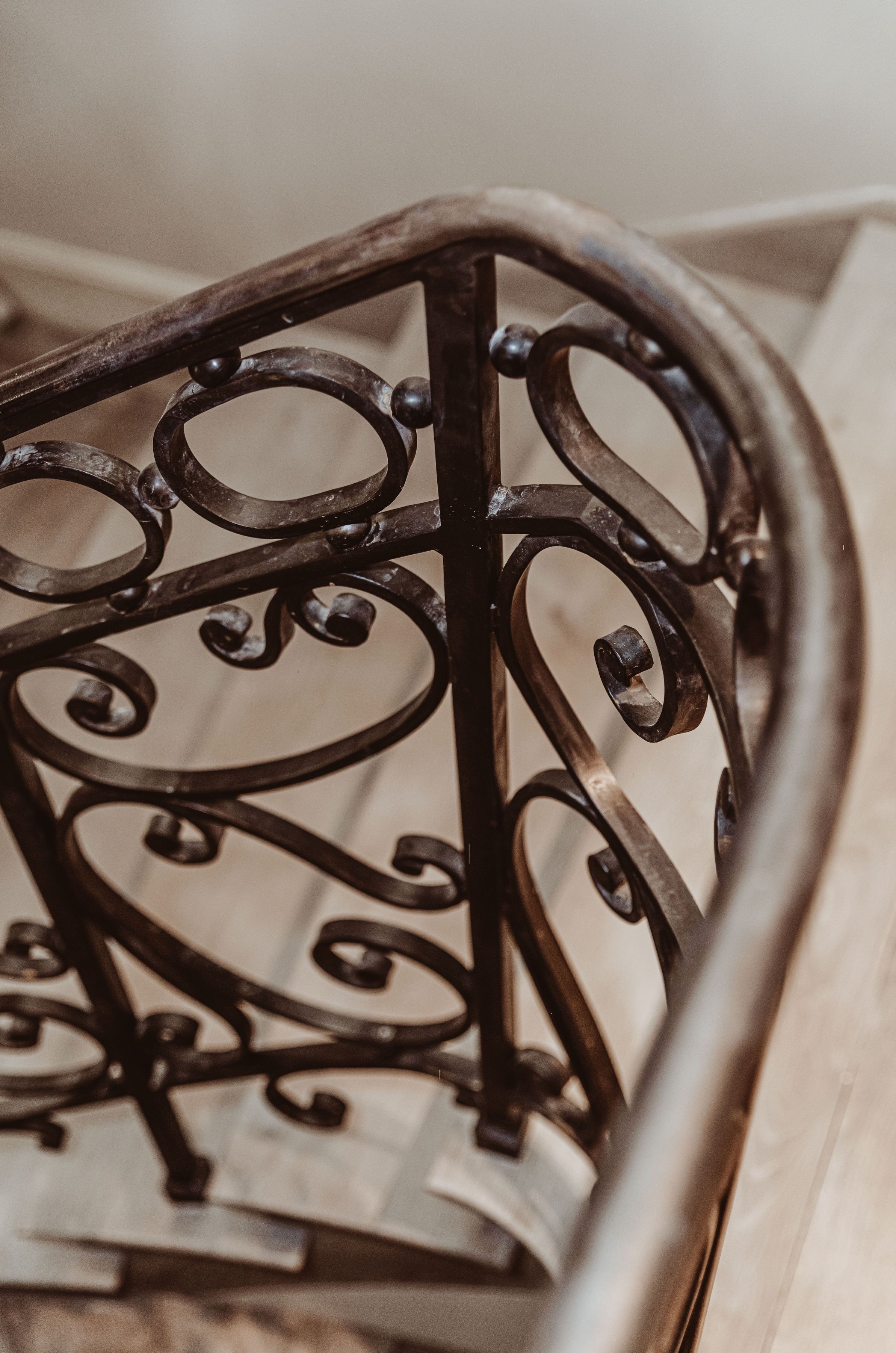 A close-up of a metal chair with intricate scrollwork design.