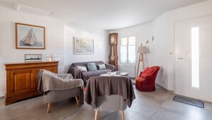 A living room with a sofa, armchairs, a coffee table, a red chair, a wooden cabinet, a clock, a map, and a lamp. - Nice family house for 6 , St Clément des Baleines (Saint-Clément-des-Baleines)