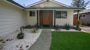 A single-story house with a front door, a small porch, and a well-maintained lawn.