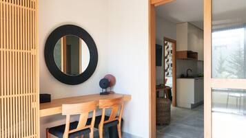 Un coin repas avec une table en bois, des chaises, un miroir rond et un objet décoratif posé sur la table.