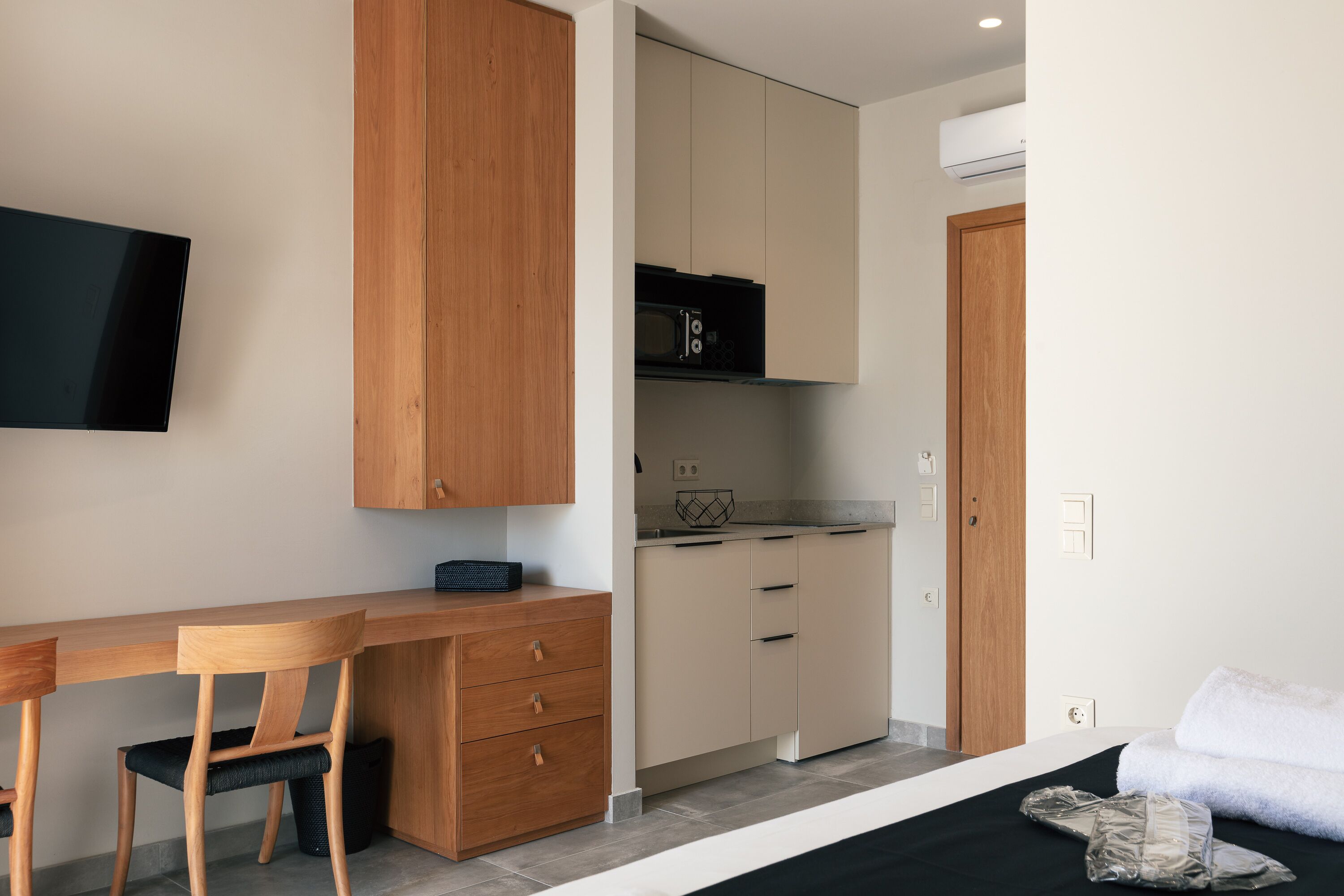 Une petite cuisine équipée d’un four à micro-ondes, d’un petit réfrigérateur et d’un meuble en bois.