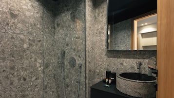 Suite | Badkamer | Een douche, een haardroger, pantoffels, handdoeken