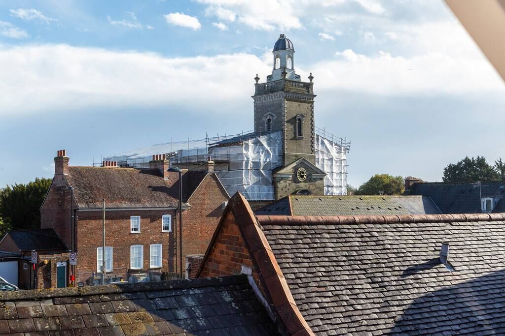 A building with a clock tower, surrounded by scaffolding, indicating possible renovation or maintenance work.