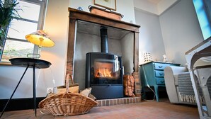 Une pièce chaleureuse avec une cheminée, un panier en osier et une lampe.