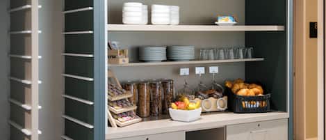 Montaje de un bufé de desayuno con diversos alimentos y recipientes.