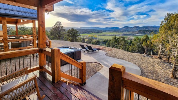 A wooden deck with outdoor seating and a hot tub overlooking a scenic landscape. - Juniper Mountain Retreat |Hot Tub|Game Room| Views (Orderville)