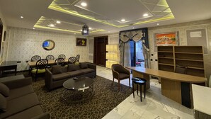 A modern living room with a sofa, coffee table, and dining area. - BEST PREMIER MAITAMA RESIDENCE (Abuja)