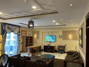 A modern living room with a flat-screen TV, comfortable seating, a coffee table, and a dining area. - BEST PREMIER MAITAMA RESIDENCE (Abuja)