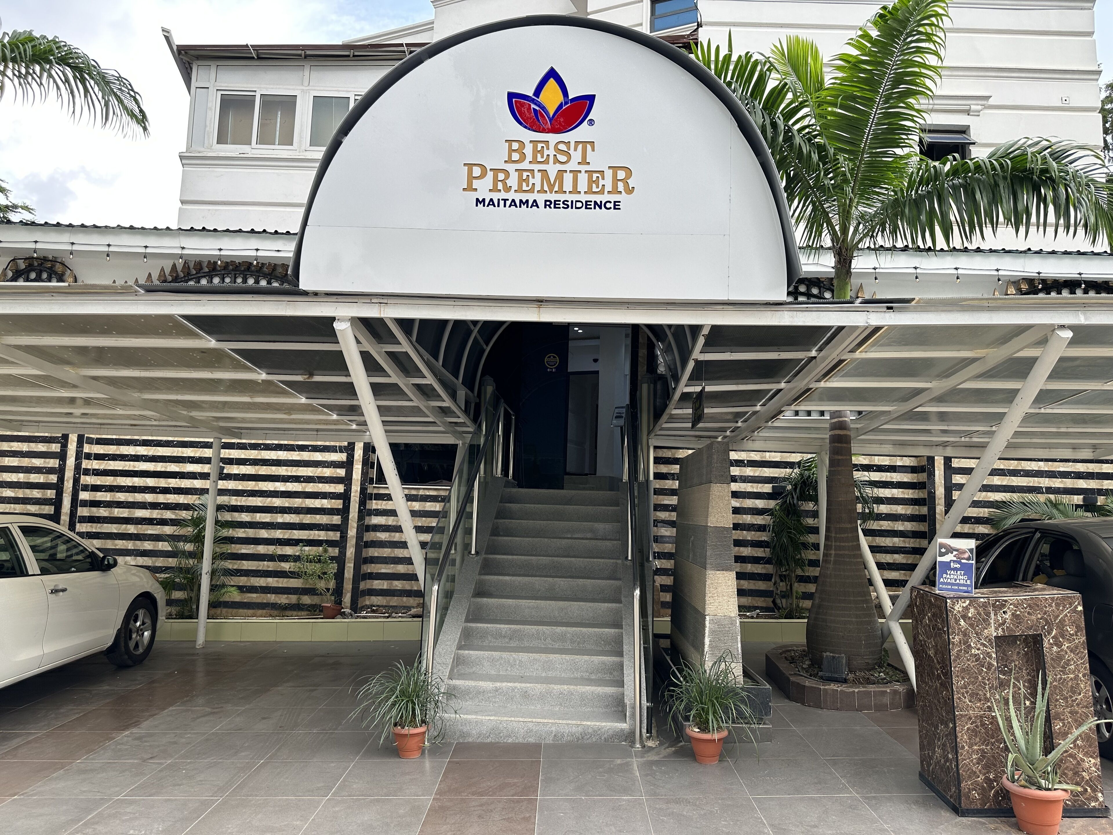 A hotel entrance with a sign reading "Best Premier Maitama Residence."