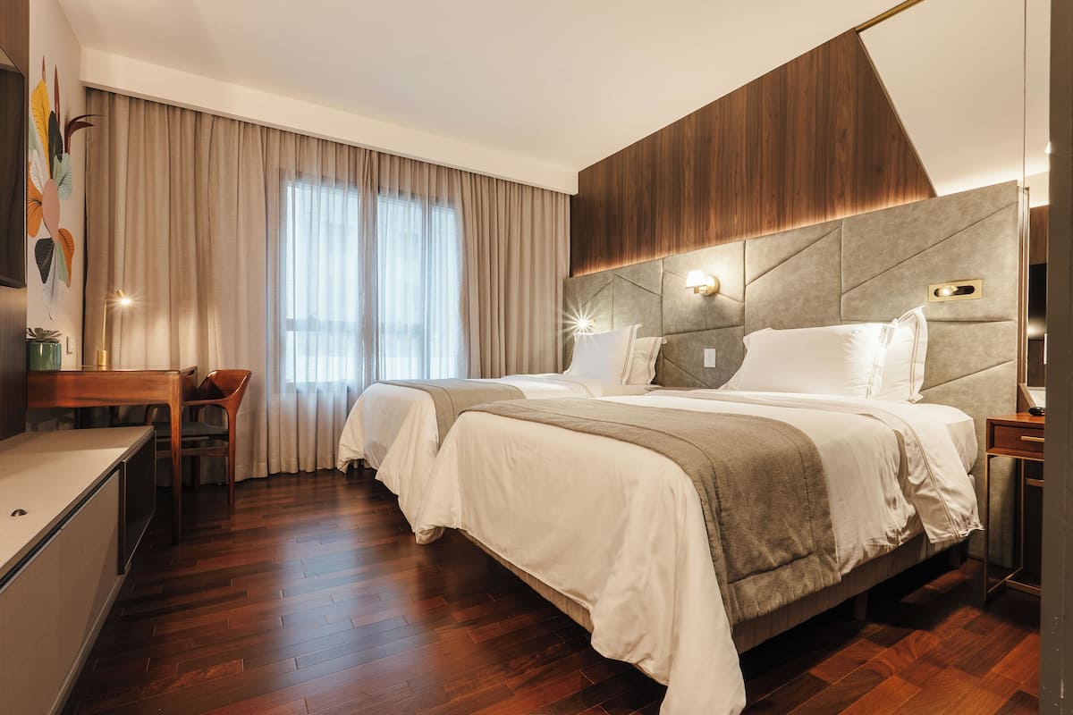 Una cama doble con cabecera de madera, una mesita de noche y una silla.