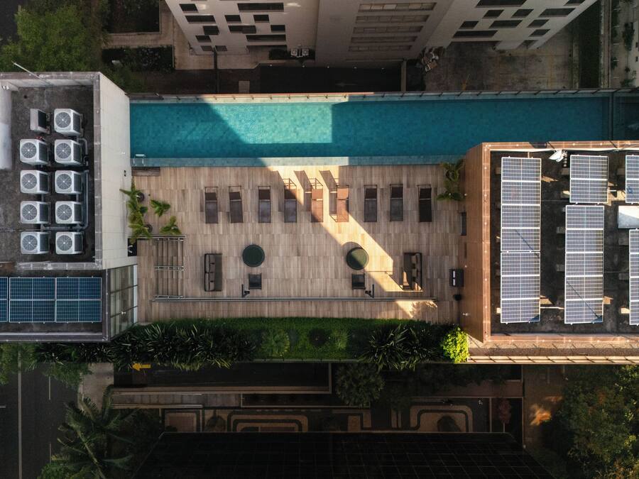Vista aérea de una azotea con piscina, varias unidades de aire acondicionado y paneles solares.