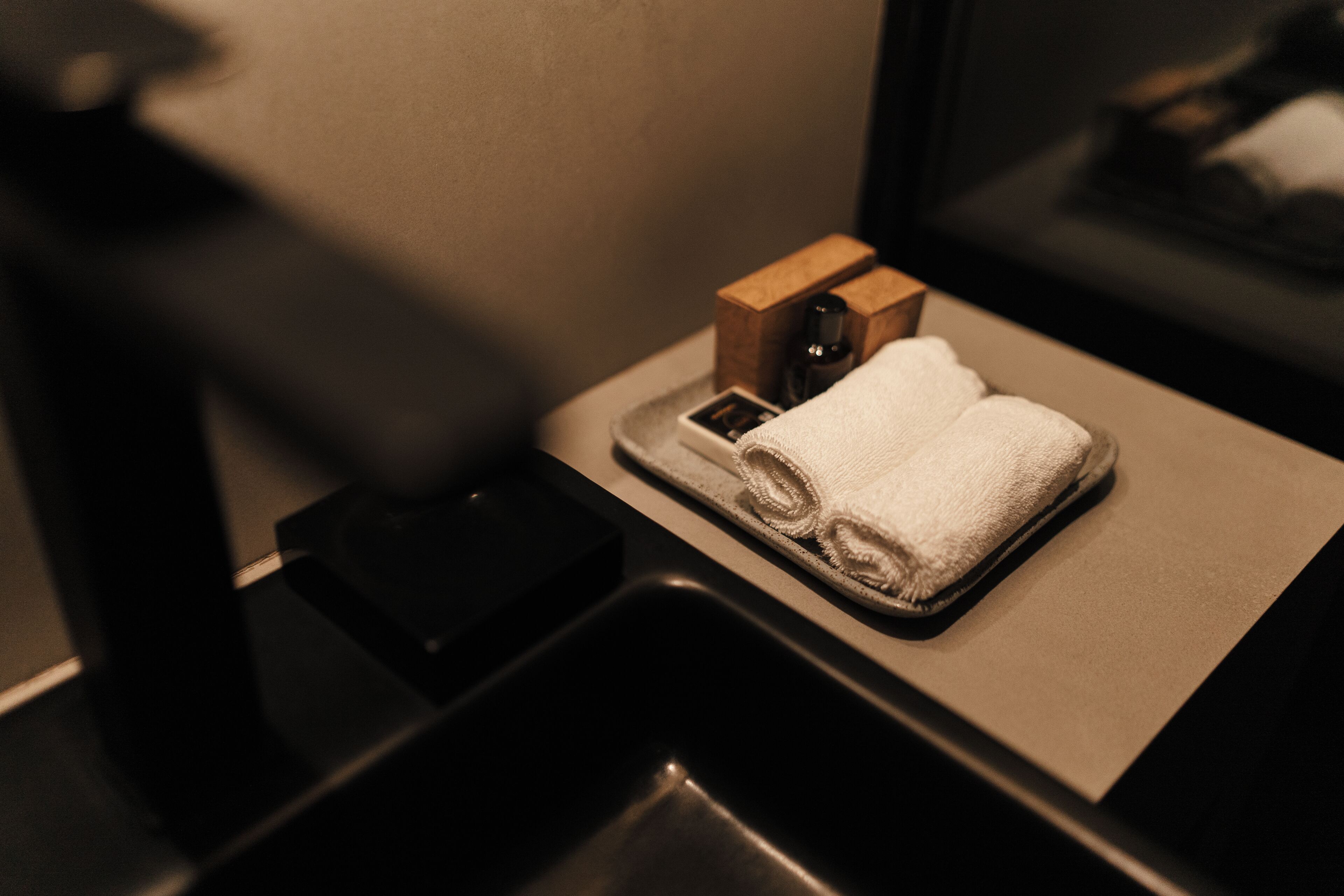 Ein Badezimmer mit Waschbecken, Handtuch und einer Holzkiste.