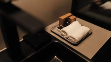 A bathroom with a sink, a towel, and a wooden box.