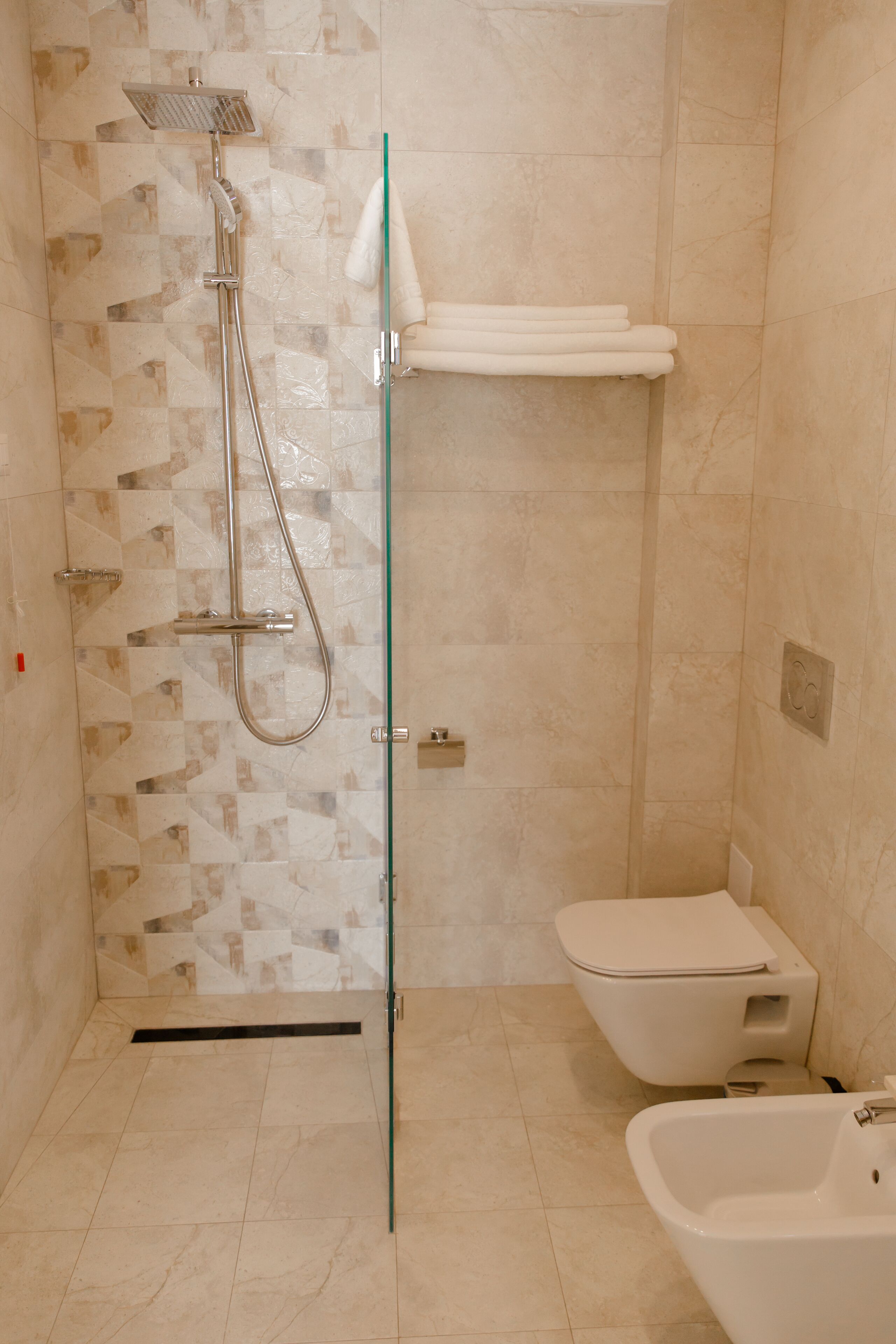 A bathroom with a glass-enclosed shower, a toilet, and a bathtub.
