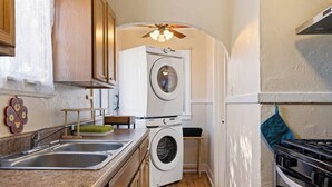 A compact kitchen with a washing machine, a sink, and a stove. - Hot Summer Deals Cute Clean Quiet Dog Friendly (Phoenix)