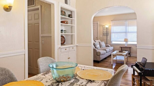 A dining area with a table set for two, a piano, and a sofa in the background. - Hot Summer Deals Cute Clean Quiet Dog Friendly (Phoenix)