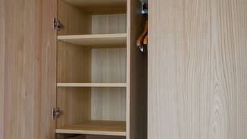 An open wooden wardrobe with multiple shelves and a hanging rod.