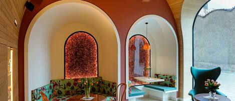 A modern interior with wooden ceiling, arched seating, and a central table.