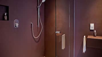 Ein modernes Badezimmer mit Duschkabine aus Glas, integriertem Waschtisch und Handtuchhalter.