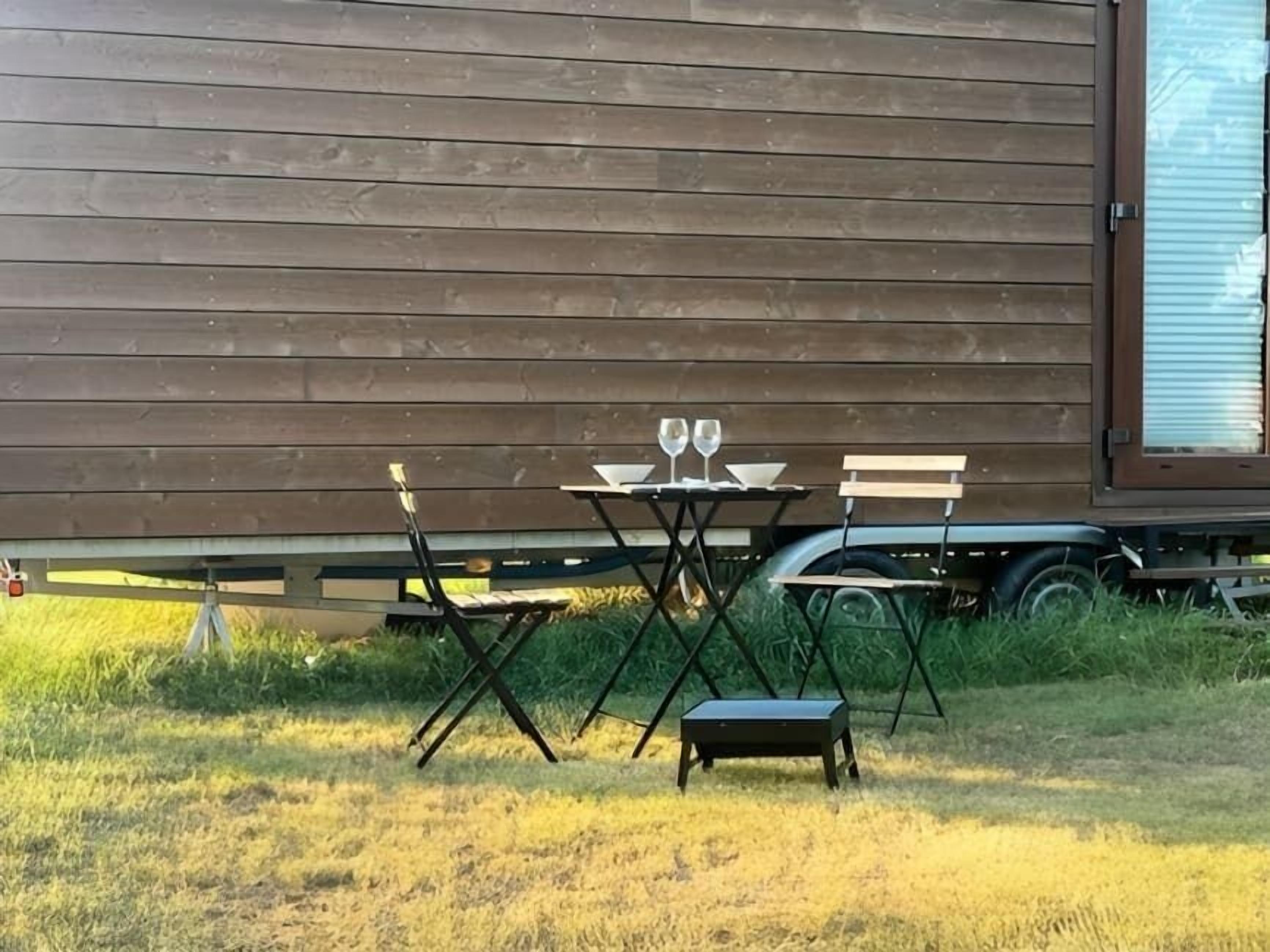 Eine Holzhütte mit Tisch und Stühlen davor.