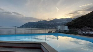 Une piscine avec vue sur les montagnes et la mer.