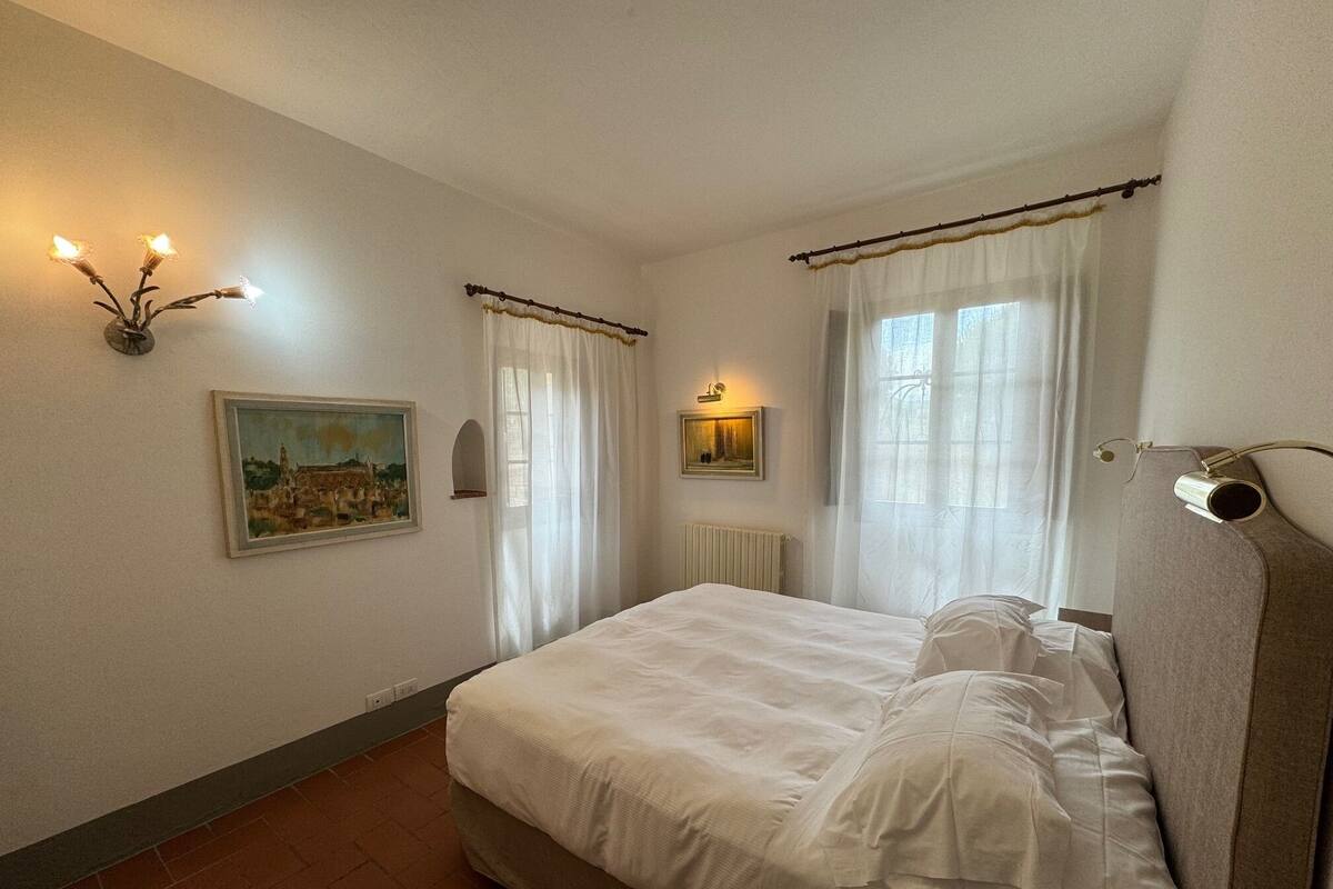 Un dormitorio con una cama grande, un cuadro en la pared y un radiador.