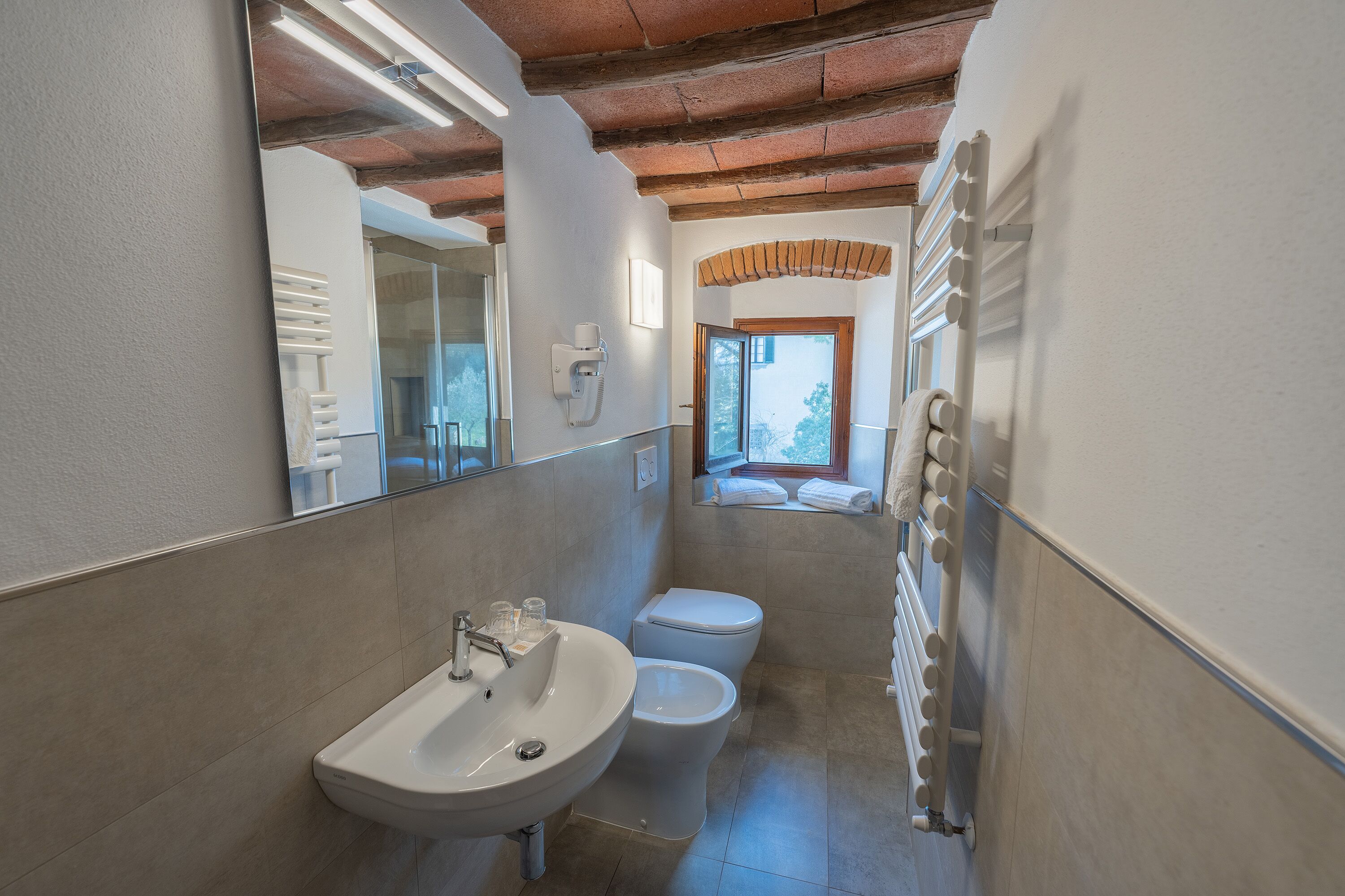 A bathroom with a sink, toilet, and a mirror.