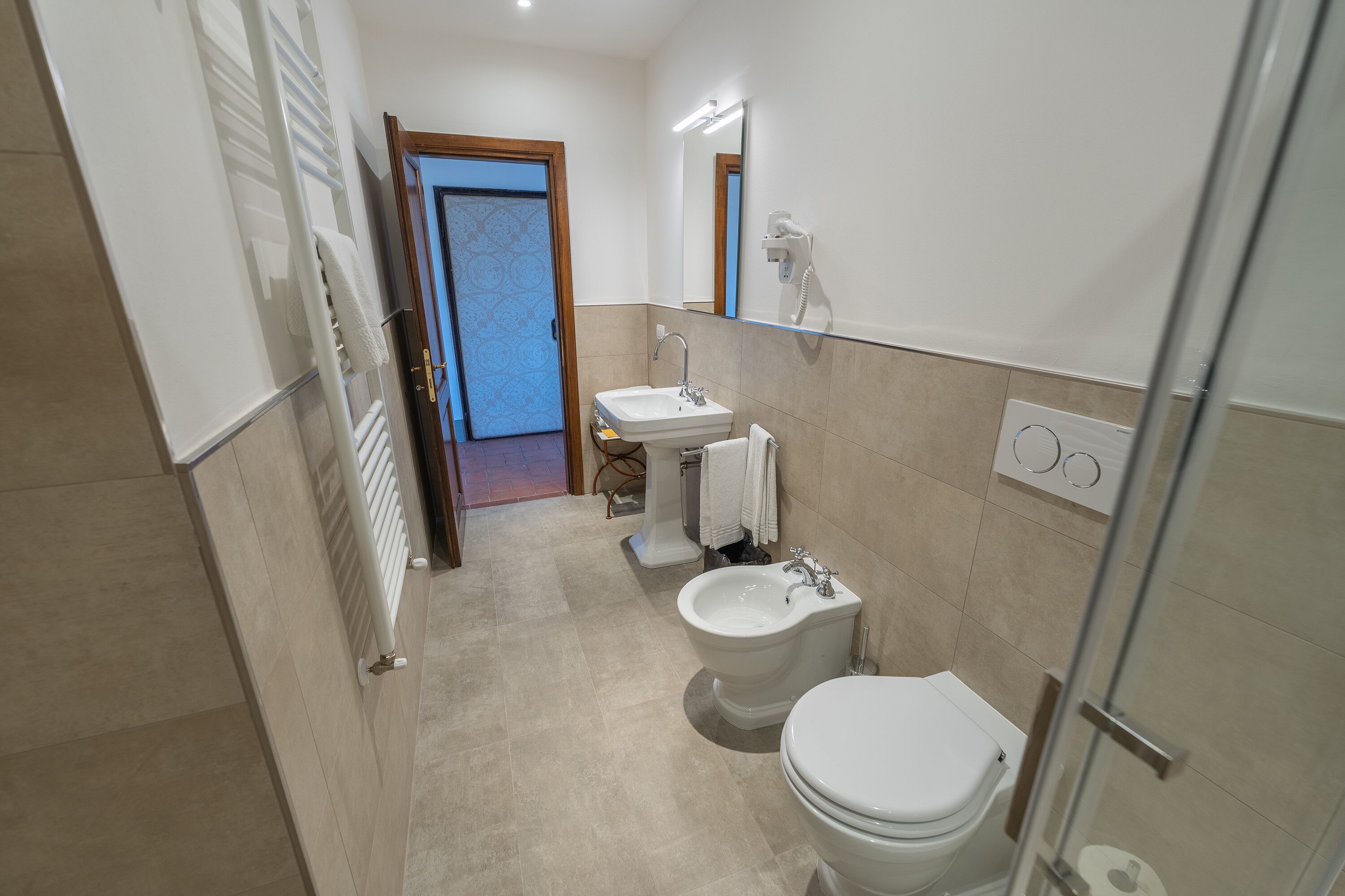 A modern bathroom with a bidet, toilet, and sink.