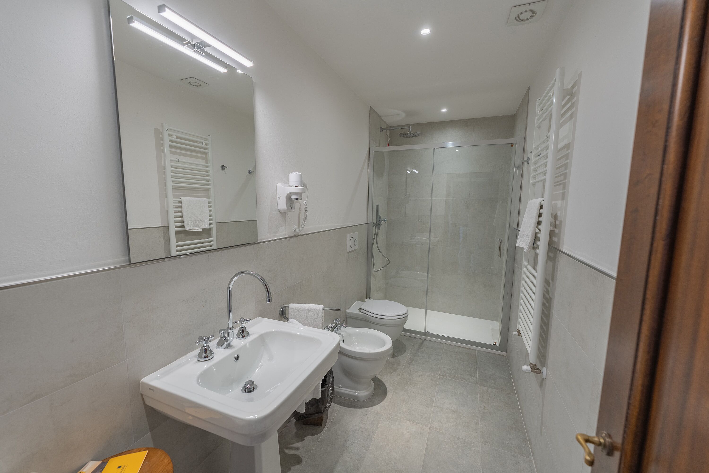 A modern bathroom with a sink, toilet, and glass shower enclosure.