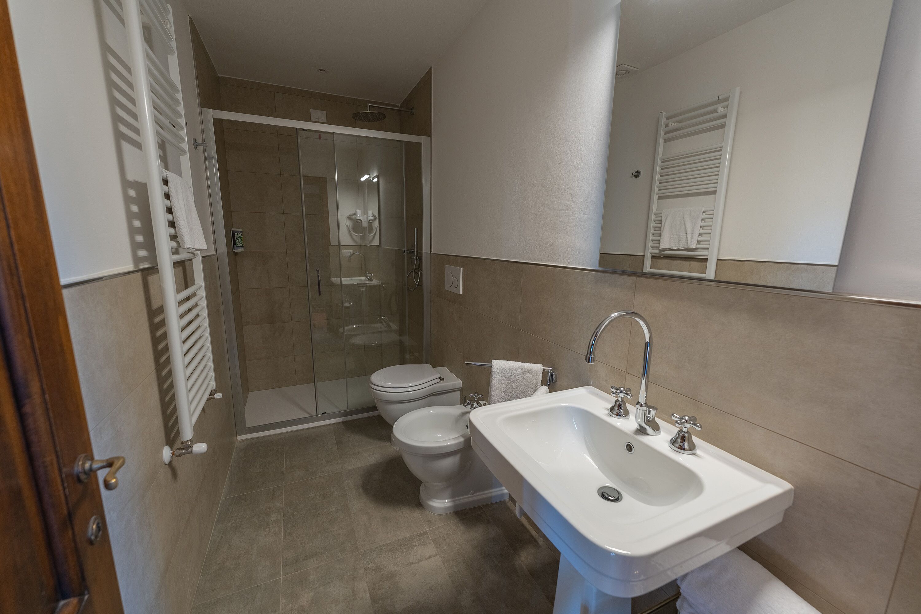 A bathroom with a white sink, a toilet, and a glass-enclosed shower.