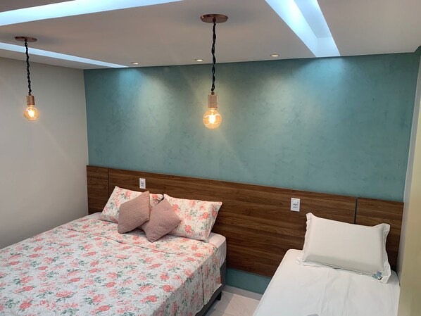 A bedroom with a bed, two bedside tables, and a ceiling light fixture. - Pousada Beija Flor (Maceió)