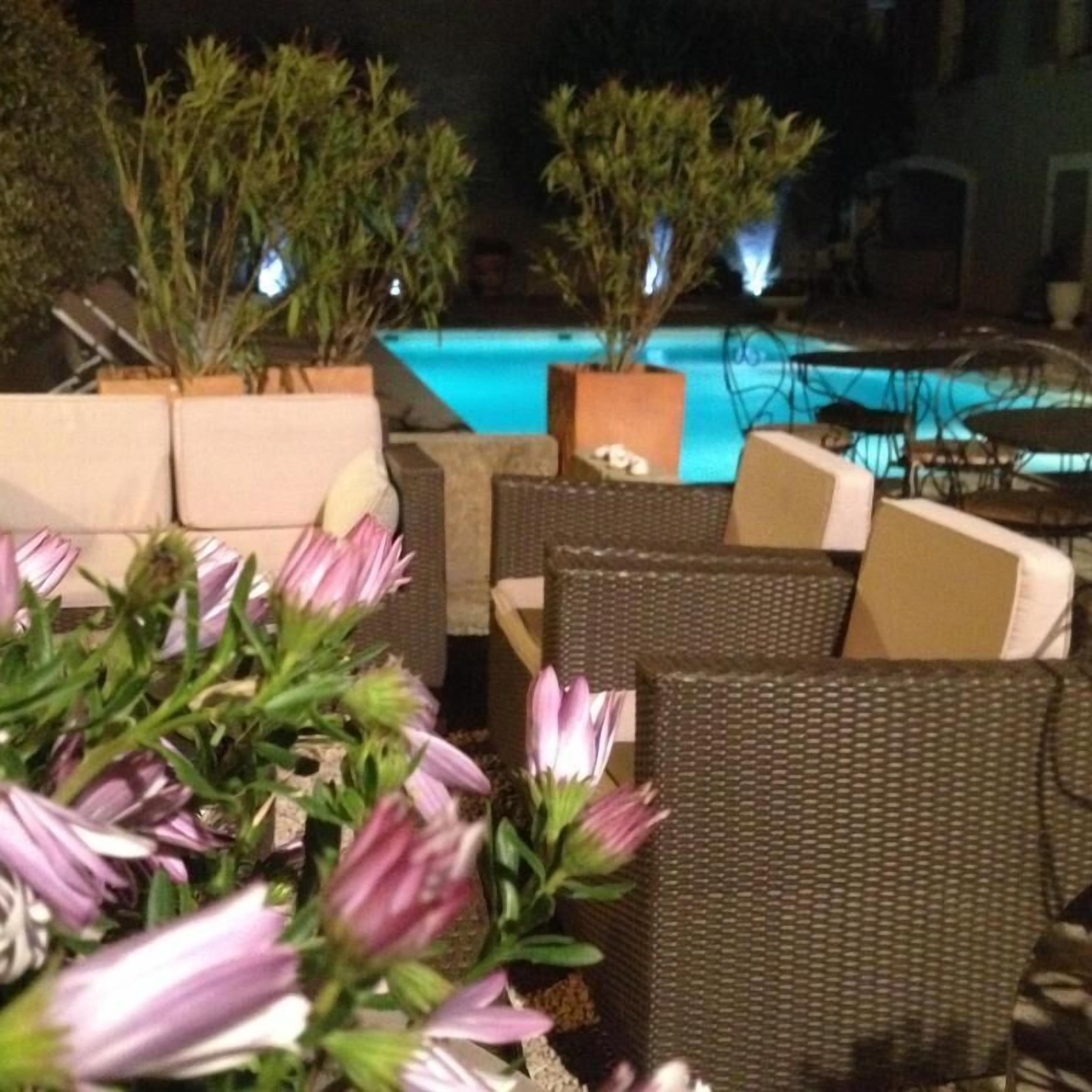 Seients exteriors amb una piscina al fons.