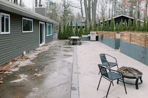 Enjoy al fresco dining and relaxation in this backyard with a patio, fire pit, and grill.