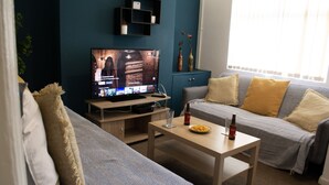 A living room with a TV, sofa, and coffee table. - 2 bed house Sedley Street Liverpool (Liverpool)