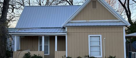 A single-story house with a gabled roof, a front porch, and a mailbox.