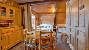 Ein Holzblockhaus-Innenraum mit Essbereich, Küche und einem gemütlichen Wohnbereich.