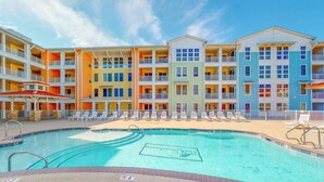 Un hotel a più piani con piscina, area salotto all'aperto e facciate colorate.