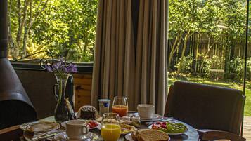 Una mesa de desayuno con vistas a un jardín exuberante y montañas.