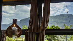 Quarto com uma janela grande, cortinas e um lustre.