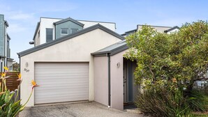 A modern two-story house with a garage, number 237, surrounded by a well-maintained garden with various plants and a bird of paradise flower. - Eastern Views - Modern living with pool and table tennis. (Portarlington)
